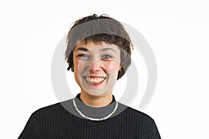 Positive smiling short-haired young adult woman looking at camera with a toothy smile. Closeup portrait. Studio shot.