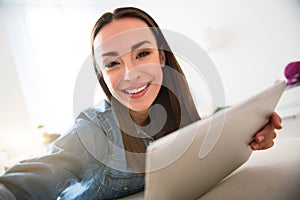 Positive smiling woman resting on the couch
