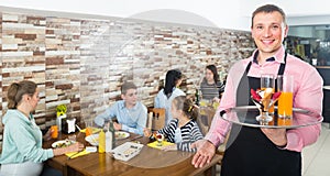 waiter warmly welcoming guests to cozy family cafe