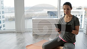 Positive sportive woman using a tablet