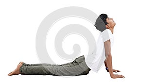 Positive sporty Indian boy enjoying yoga in fitness studio, doing stretching asana Bhujangasana