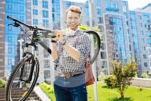 Positive strong man holding his bicycle