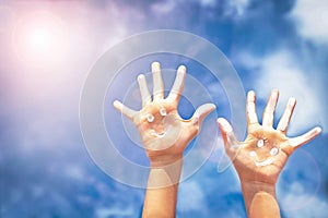 Positive symbol drawing by sunscreen (sun cream, suntan lotion) on two hands.