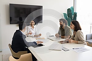 Positive teammates take part in briefing, laughing, enjoy pleasant conversation photo