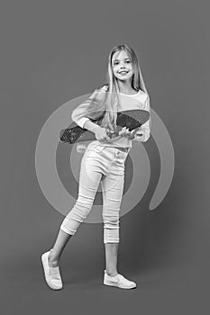 positive teen girl skateboarder isolated on purple. teen girl skateboarder in studio. photo