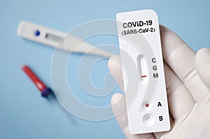 Positive test result by using rapid test for COVID-19, quick fast antibody point of care testing. Lab performing rapid photo
