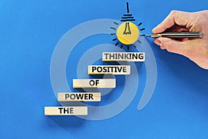 Positive thinking symbol. Concept words The power of positive thinking on wooden block. Beautiful blue background. Businessman