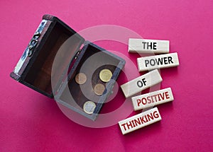 Positive Thinking symbol. Wooden blocks with words The Power of Positive Thinking. Beautiful red background with money box.