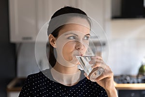 Positive thirsty young woman drinking fresh clean pure water