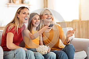 Positive three generations family watching TV at home