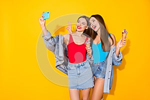Positive two people youth sisters girls bloggers enjoy summer trip take selfie smartphone hold tasty yummy icecream make