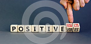 Positive vibes results symbol. Concept words Positive vibes or Positive results on cubes. Businessman hand. Beautiful grey table