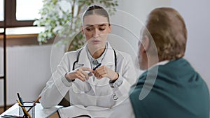 Positive woman doctor talking with unrecognizable senior man patient during appointment, tracking shot, slow motion