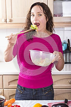 Positive woman eating vegetable salad