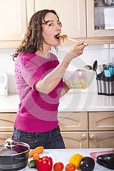 Positive woman eating vegetable salad