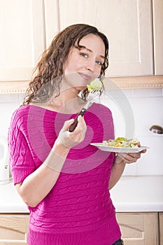 Positive woman eating vegetable salad