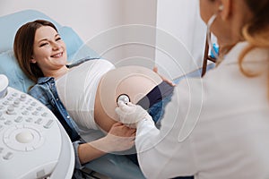 Positive woman getting pregnant belly examination in the hospital