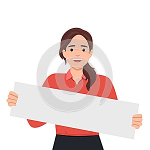 Positive woman holding blank white placard smiling and looking at camera demonstrating banner with copy space. Young girl teenager