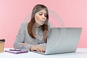 Positive woman office worker looking at laptop screen with humorous fish face grimace, fooling face talking on video call, online