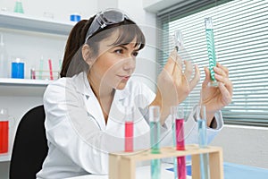 positive woman smiling while looking at test tube