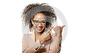 Positive Woman surprise showing product. Attractive young female with Afro hairstyle presenting product. Girl points aside with