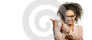 Positive Woman surprise showing product. Attractive young female with Afro hairstyle presenting product. Girl points aside with
