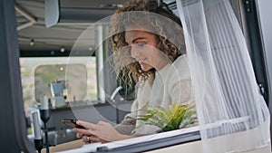 Positive woman texting mobile phone in campsite close up. Smiling lady watching