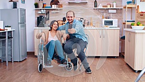 Positive woman in wheelchair and husband taking a selfie