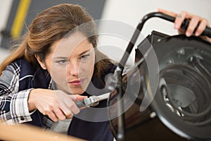 positive woman worker fixing heating system with special tool