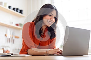Positive woman working on a laptop at home