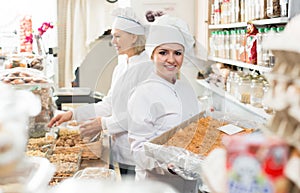 Positive women staff offering sweets