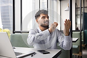 Positive young Arab businessman using invisible virtual interface