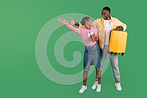 Positive young black couple going vacation, holding passports, suitcase