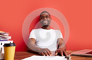 Positive young black man sit at office desk