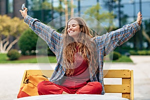 Positive young blonde hipster woman student with backpack celebrate success at university.