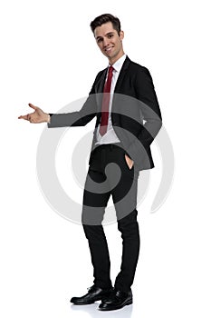 Positive young businessman presenting and standing