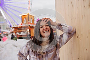 Positive young caucasian girl wide smiling at camera spends leisure time at amusement park.