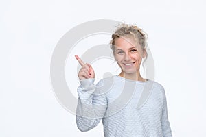 Girl with curly blonde hair smiling cheerfully and pointing with forefingers photo