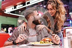 Positive young loving couple in cafe