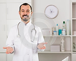 Positive young male doctor ready to receive clients