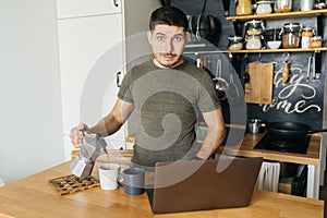 Positive young man remotely pours himself coffee