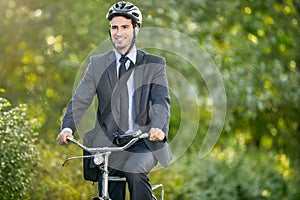 Positive young man riding a bicycle to work