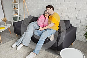 positive young man sitting on couch