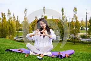Positive young sporty woman show love heart