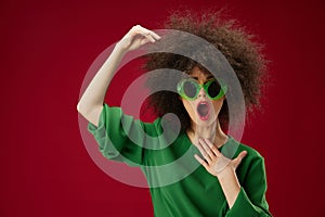 Positive young woman curly hairstyles green dress red background unaltered