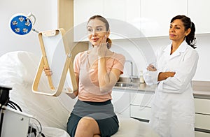 Positive young woman evaluating quality of cosmetological procedures
