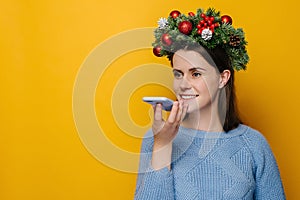 Positive young woman holds phone talks on speakerphone with friend, makes voice recognition or request uses internet services