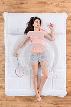 Positive young woman lying on bed