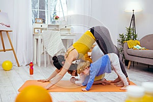 Positive young woman working out with her children