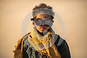 Post apocalyptic boy outdoors in desert.